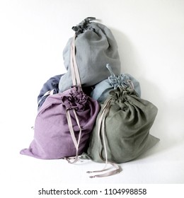 Linen Drawstring Bag Full Of Laundry On White Background.