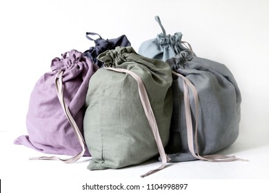 Linen Drawstring Bag Full Of Laundry On White Background.