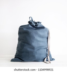 Linen Drawstring Bag Full Of Laundry On White Background.