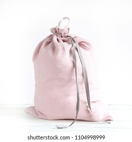 Linen Drawstring Bag Full Of Laundry On White Background.