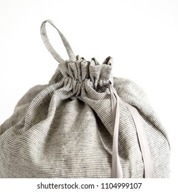 Linen Drawstring Bag Full Of Laundry On White Background.