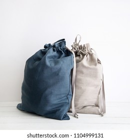 Linen Drawstring Bag Full Of Laundry On White Background.