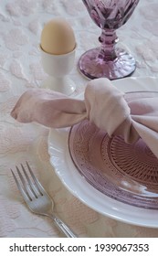 A Linen Napkin Tied In A Knot. Pink Napkin On A Plate. How To Tie A Napkin. Fragment. Vertical.