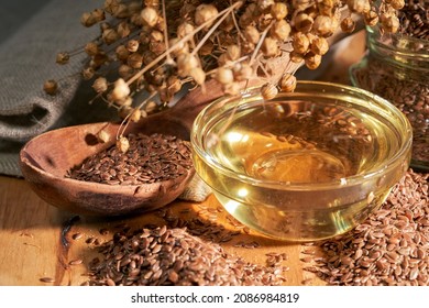 Linen seeds and oil in a glass jar and wooden spoon, selective focus, close up. Linseed oil obtained  from the ripened seeds. Flaxseed oil as dietary supplement, is a source of α-Linolenic acid.