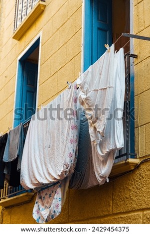 Linen and sheets drying on the balcony. Laundry hanging in the streets of Southern Europe. Mediterranean city atmosphere. Laundry hanging outside in the city