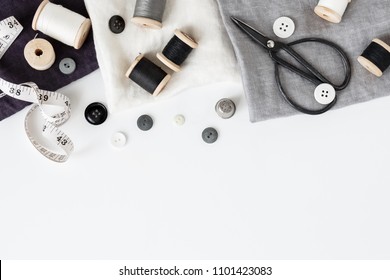 Linen textiles, scissors and sewing supplies on white desk - Powered by Shutterstock