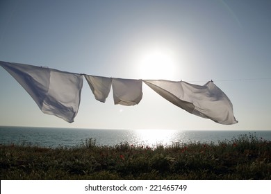 Linens Dries In The Fresh Air On A Background The Sea And Sunset