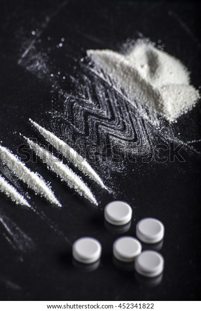 Lines of cocaine and some drugs pills.\
cocaine lines shots on a black table glass. cocaine powder, Credit\
card, close up, toned. Drug abuse\
concept