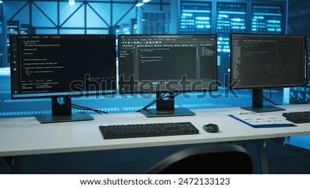 Lines of code running on computer screens in data center, used for troubleshooting rackmounts in server rows. Close up shot of script working on PC monitors upgrading hardware