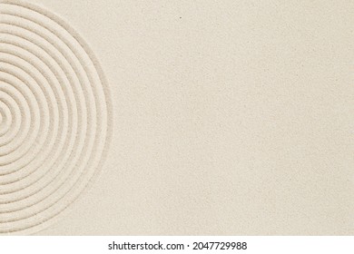 Lines drawing on sand, beautiful sandy texture. Spa background, concept for meditation and relaxation. Concentration and spirituality in Japanese zen garden. View from above.