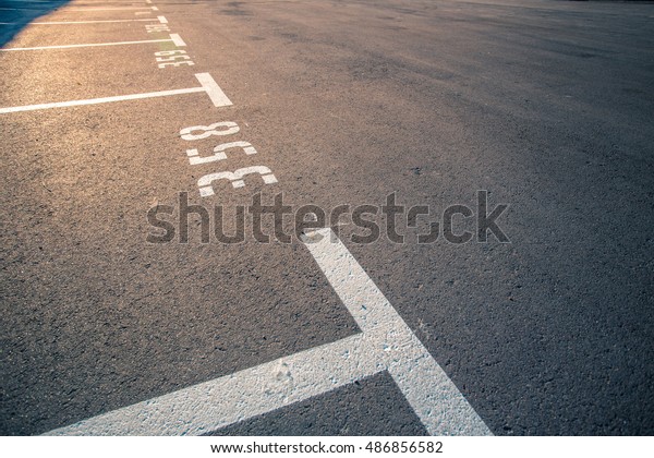 Lines parking, a detailed indication lines\
on the asphalt\
Asphalt surface of the empty parking with white\
road marking lines and place\
numbers.