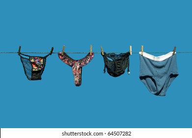 Lingerie  beside men's briefs hanging on a clothesline against a brilliant blue sky with copy space.