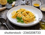 Linguine al limone - pasta with lemon and parmesan on wooden background
