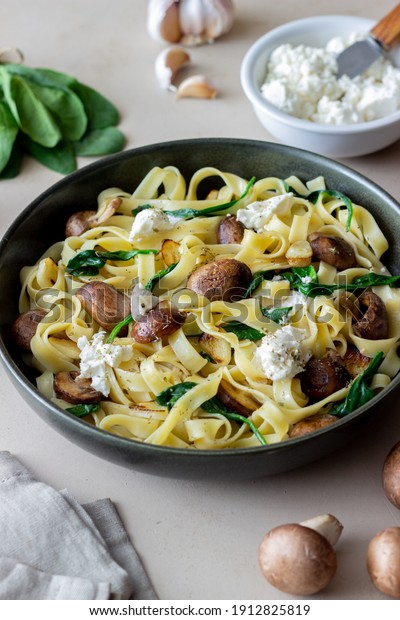 Linguine pasta with\
mushrooms, white cheese, spinach and garlic. Healthy eating.\
Vegetarian food. Diet