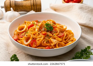 Linguine pasta with squid and cherry tomato in tomato sauce in white plate - Powered by Shutterstock