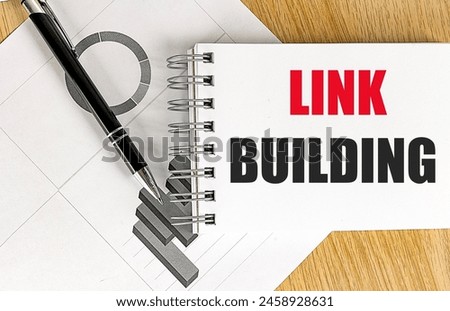 LINK BUILDING text on a notebook with chart on wooden background. 