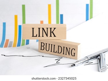 LINK BUILDING text on wooden block on chart background, business concept