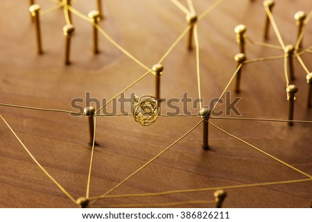 Linking entities. Dispute or conflict, or Bottleneck  between two entities. Network, networking, social media, internet communication abstract. Web of gold wires on rustic wood.