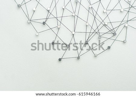 Linking entities, Network simulation, social media, Communications Network, The connection between the two networks. in paper linked together by cotton with a black yarn