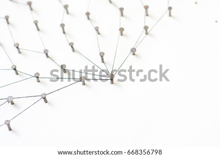 Linking entities, Network simulation, social media, Communications Network, The connection between the two networks. in paper linked together by cotton with a black yarn