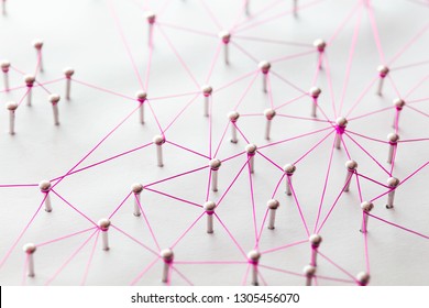 Bindeglieder Netzwerke, Social Media, SNS, Internetkommunikation abstrakt. Kleines Netzwerk, das an ein größeres Netzwerk angeschlossen ist. Netz aus rosa oder roten, Drähten auf weißem Hintergrund.