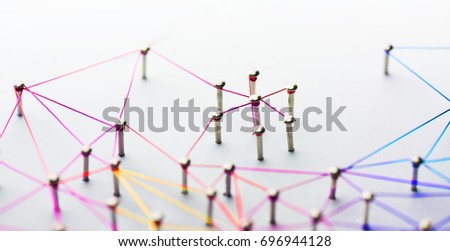 Linking entities. Networking, social media, SNS, internet communication abstract. Small network connected to a larger network. Web of red,orange yellow and blue wires on white background. Shallow DOF