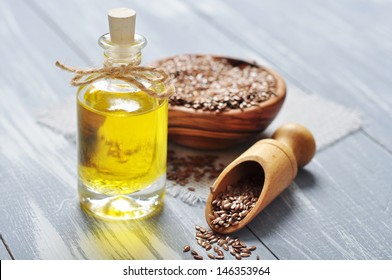 Linseed oil and flax seeds on wooden background