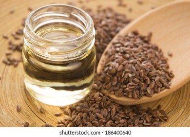 Linseed oil and flax seeds on wooden background