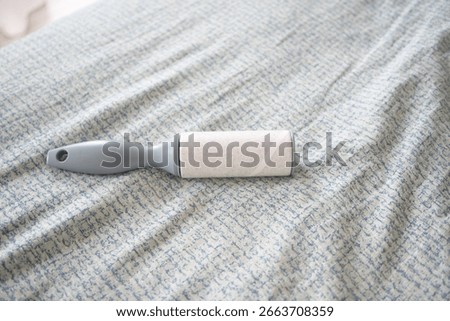 Lint roller placed on a patterned bedspread for cleaning
