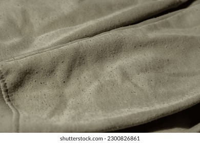 Lints on green sweater. Before cleaning and collected fluff lint. Closeup Pilled Clothes. Old used Clothes with lint pilling. Restoration of old damaged care. Repairing fabric textile reducing - Shutterstock ID 2300826861