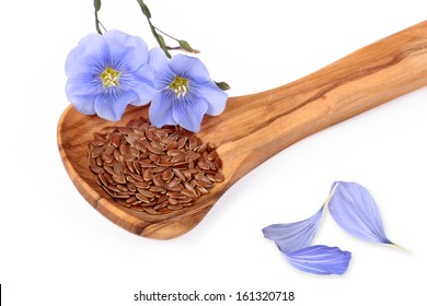 Linum blossoms, flaxseed on wooden spoon