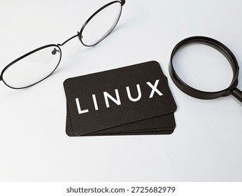 Linux operating system concept with business card, glasses, and magnifying glass on white background. Programming, development, and IT technology.