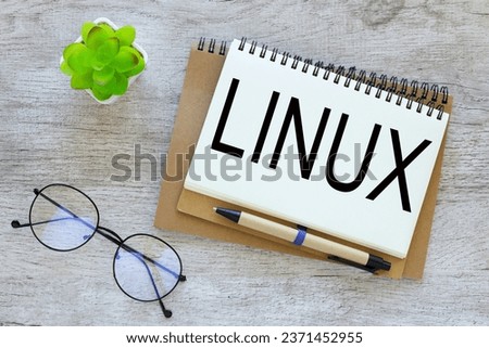 LINUX text on a notepad page on a craft notepad next to glasses