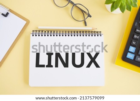LINUX. Text written in Noebook on light background. Technology concept. Flat lay
