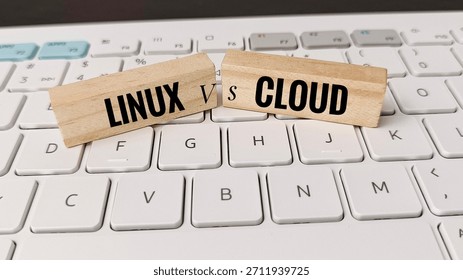 Linux versus cloud computing concept with wooden blocks on white keyboard, illustrating IT infrastructure, open source, server hosting, data management, software development. 