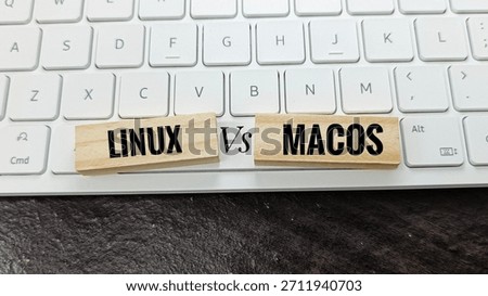 Linux versus macOS concept with wooden blocks on keyboard, illustrating operating system comparison, technology, computing, software development, IT solutions, and digital platforms. 