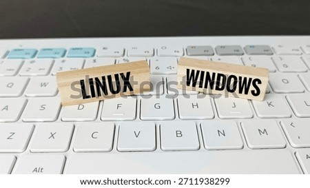 Linux versus Windows operating systems concept with wooden blocks on keyboard, illustrating software comparison, technology choice, IT solutions, and digital platforms. 