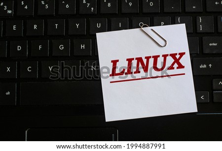 LINUX - word on a white sheet against the background of the laptop keyboard. Internet concept