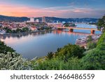 Linz, Austria. Aerial cityscape image of riverside Linz, Austria during spring sunset with reflection of the city lights in Danube river.