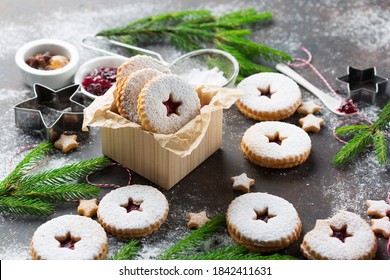 Linzer Christmas or New Year cookies filled with jam and dusted with sugar on dark background. Traditional Austrian Christmas cookies. Homemade sweet present in festive box.