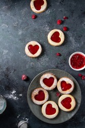 Linzer Cookies With Raspberry Jam, Red Hearts On A Blue Table. A Mess, Berries Are Lying, Powder Is Scattered. View From Above.
