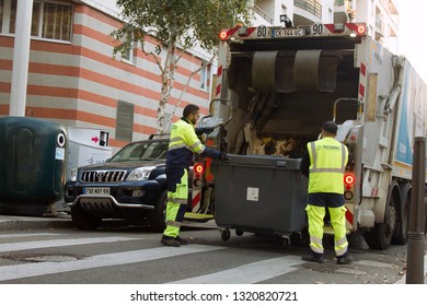 Lion, France - 14.10.2017: Two Refuse Collection Workers Loading Garbage Into Waste Truck Emptying Containers