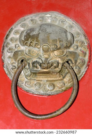 A lion red iron door knocker in the shape of a close-up 