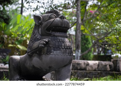 a lion statue made of stone in a garden
 - Shutterstock ID 2277874459