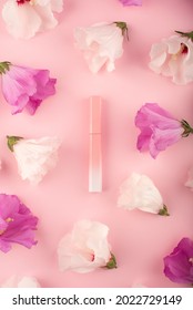 Lip gloss in pink  to  white gradient case and white   purple hibiscus flowers pink background  Flat lay trending scene and buds  Frame made flowers  Decorative cosmetics liquid lipstick