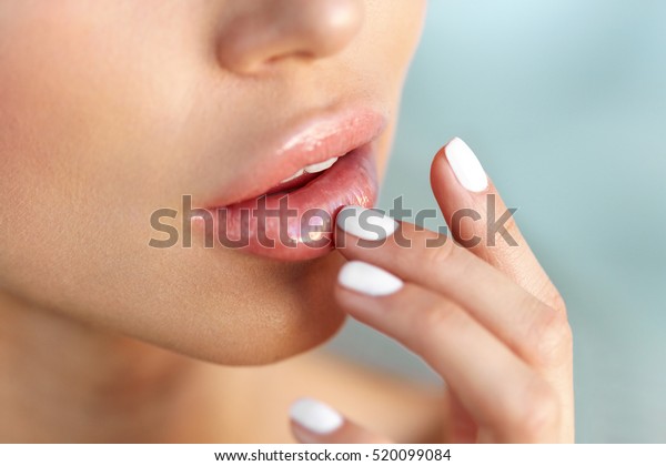 Lip\
Protection. Closeup of Beautiful Young Woman Healthy Lips. Female\
Model Mouth With Smooth Perfect Skin And Natural Manicure Touching\
Her Plush Lips. Lip Care And Beauty. High\
Resolution