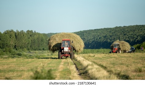 Lipetsk, Russia - July 03, 2022: Tractor Carries Dry Hay Across The Field. Hot Sunny Day.