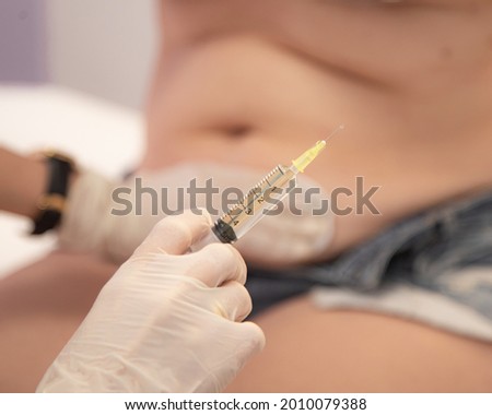 Lipotropic injections close up. Woman Belly fat dissolving treatment. Abdomen rabies vaccine