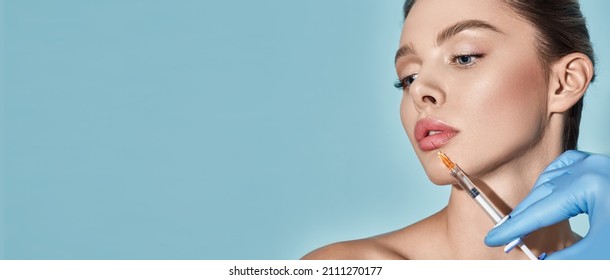 Lips Filler Injection For Beautiful Woman's Lip Augmentation With Beautician On Blue Background. Lip Augmentation Procedure