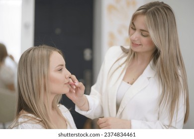 Lips  makeup, stylish visagist doing lip outline using pencil - Powered by Shutterstock